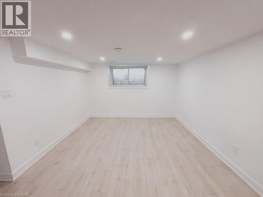 A spacious room with wooden flooring and a window.
