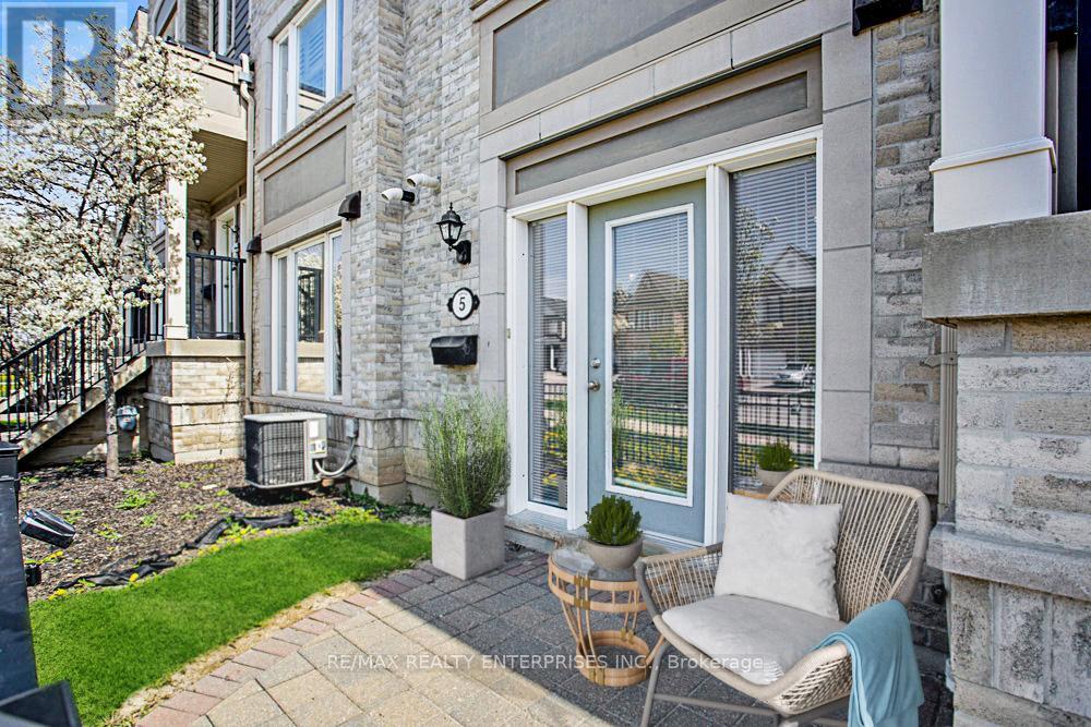 A patio with a chair and a table with a plant in a pot.