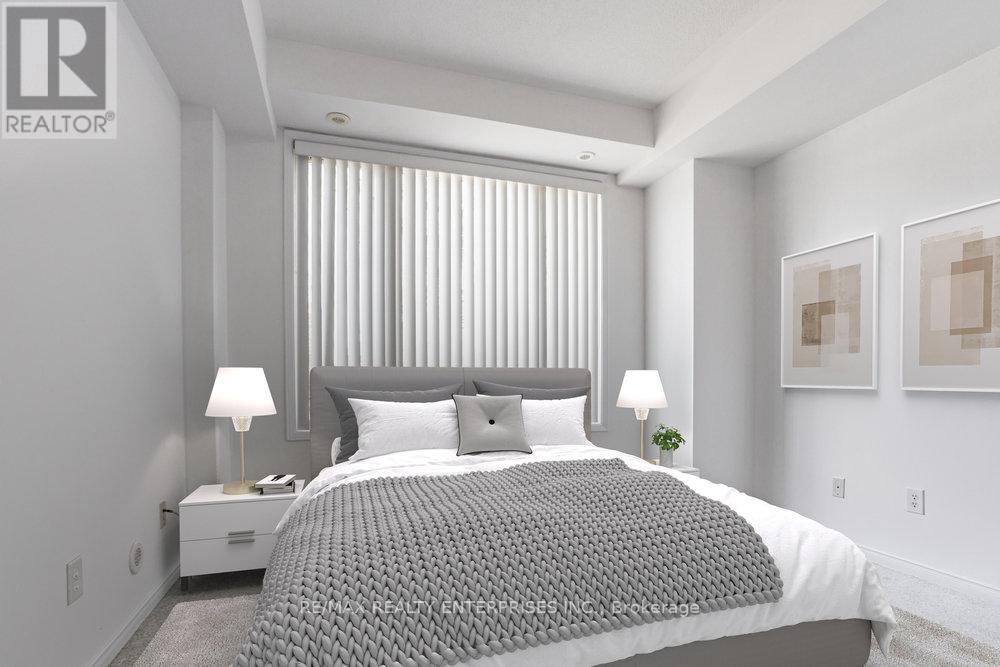 A bedroom with a large bed and two lamps.