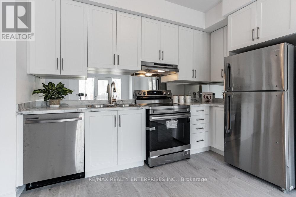 A modern kitchen with white cabinets and stainless steel appliances.