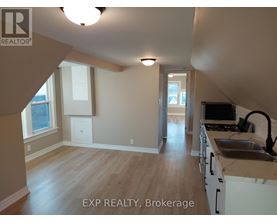 A kitchen with white cabinets and a wooden floor.