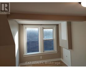 A room with a window and a sign that says EXP REALTY, Brokerage.