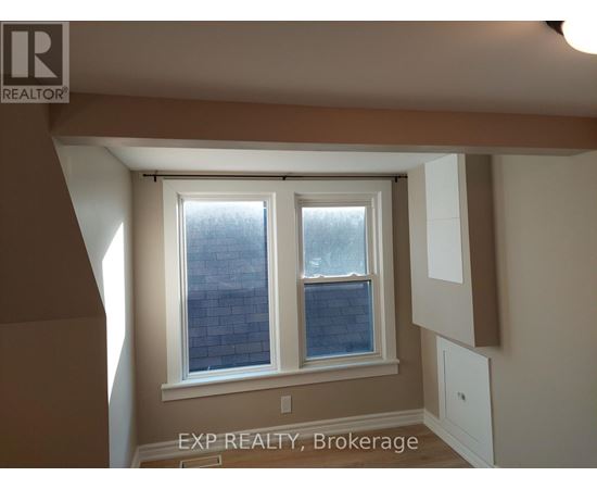 A room with a window and a sign that says EXP REALTY, Brokerage.