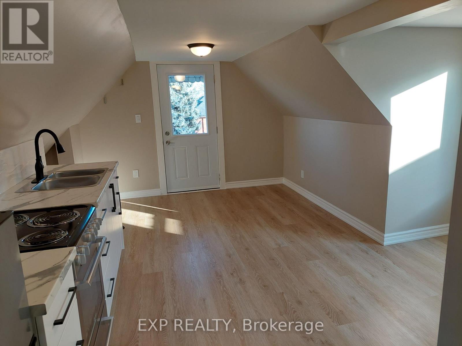 A kitchen with a stove top oven and a window.