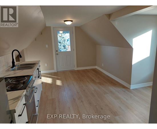 A kitchen with a stove top oven and a window.