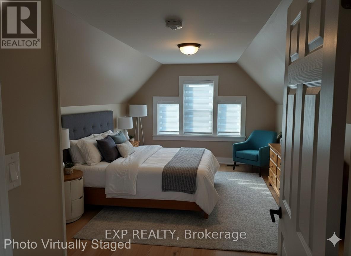A bedroom with a bed, chair, and window.