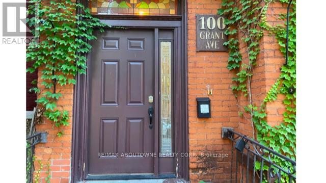 A brown door with a glass window is on the front of a brick building.