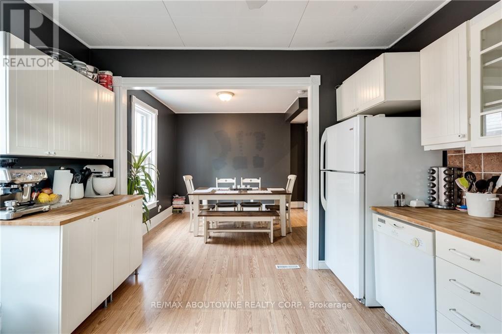 A modern kitchen with white cabinets and a wooden floor.
