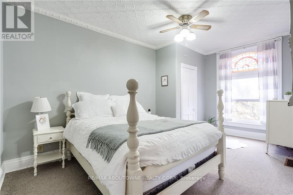A bedroom with a bed, nightstand, and window.
