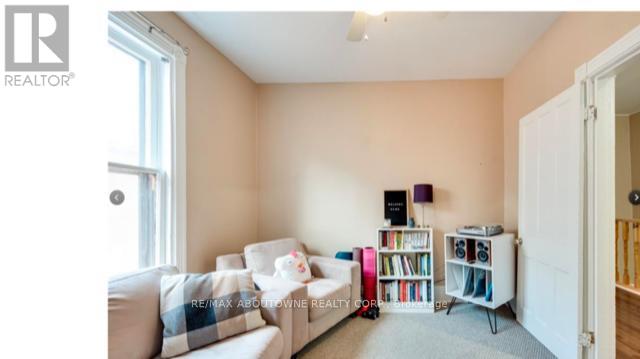A living room with a white couch and a bookshelf filled with books.