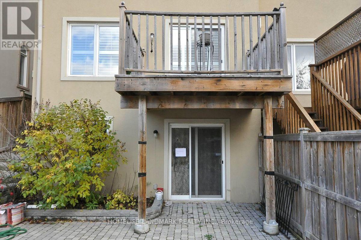 A balcony with a railing and a door is on the ground floor of a house.