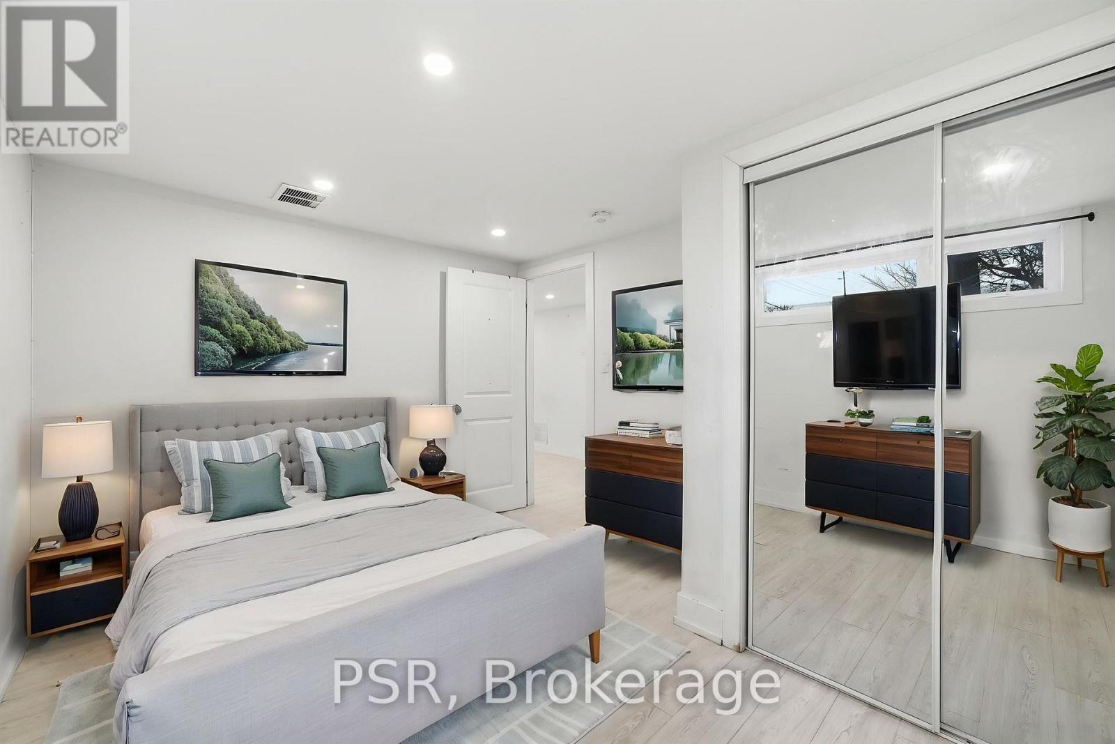 A bedroom with a large bed and a sliding glass door leading to a balcony.