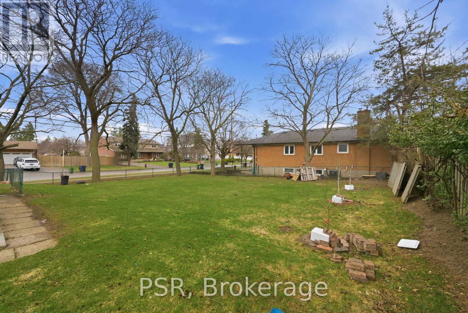 A backyard with a lawn and a few trees.