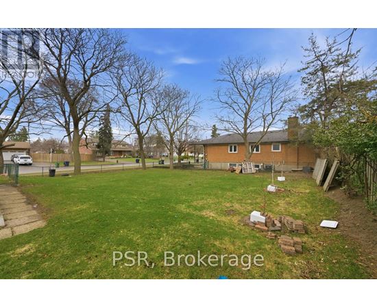 A backyard with a lawn and a few trees.