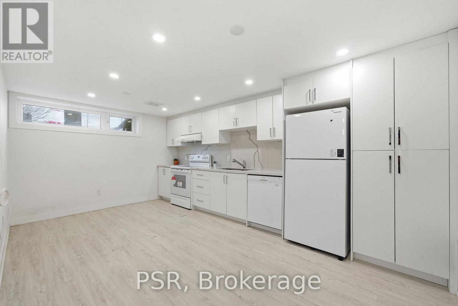 A kitchen with white appliances and cabinets is for sale.