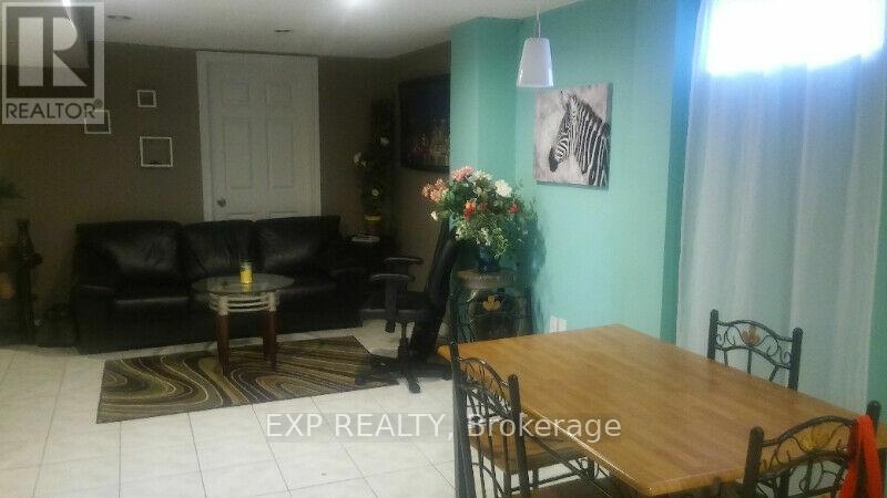 A living room with a couch, coffee table, and a dining table.