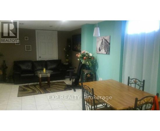 A living room with a couch, coffee table, and a dining table.