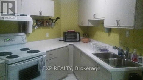 A kitchen with a stove, sink and cabinets.
