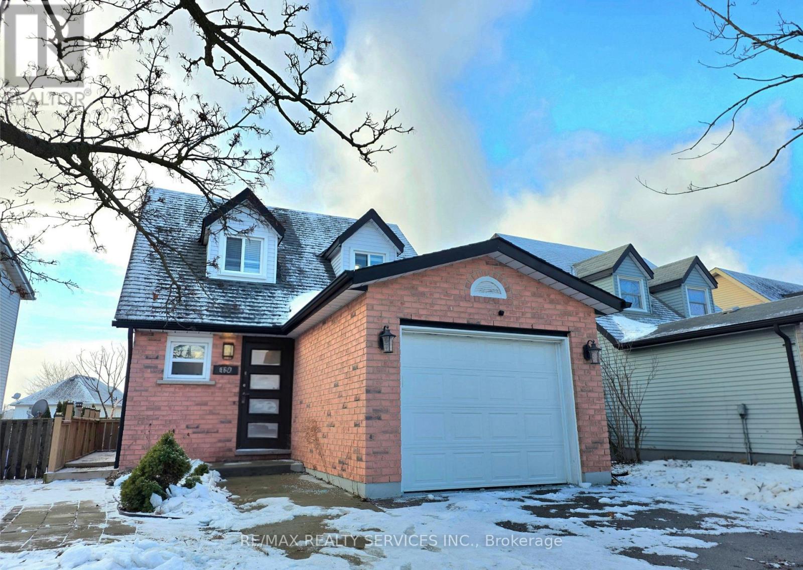 A house with a garage and a driveway covered in snow.