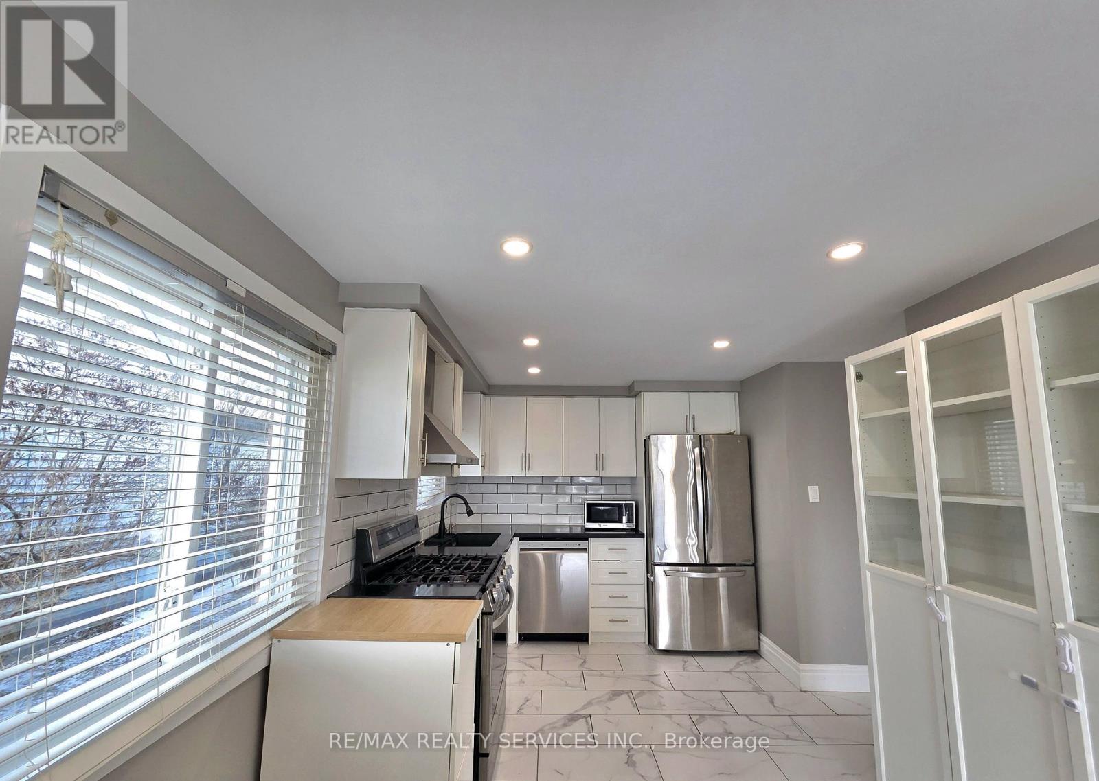 A kitchen with white cabinets and stainless steel appliances.