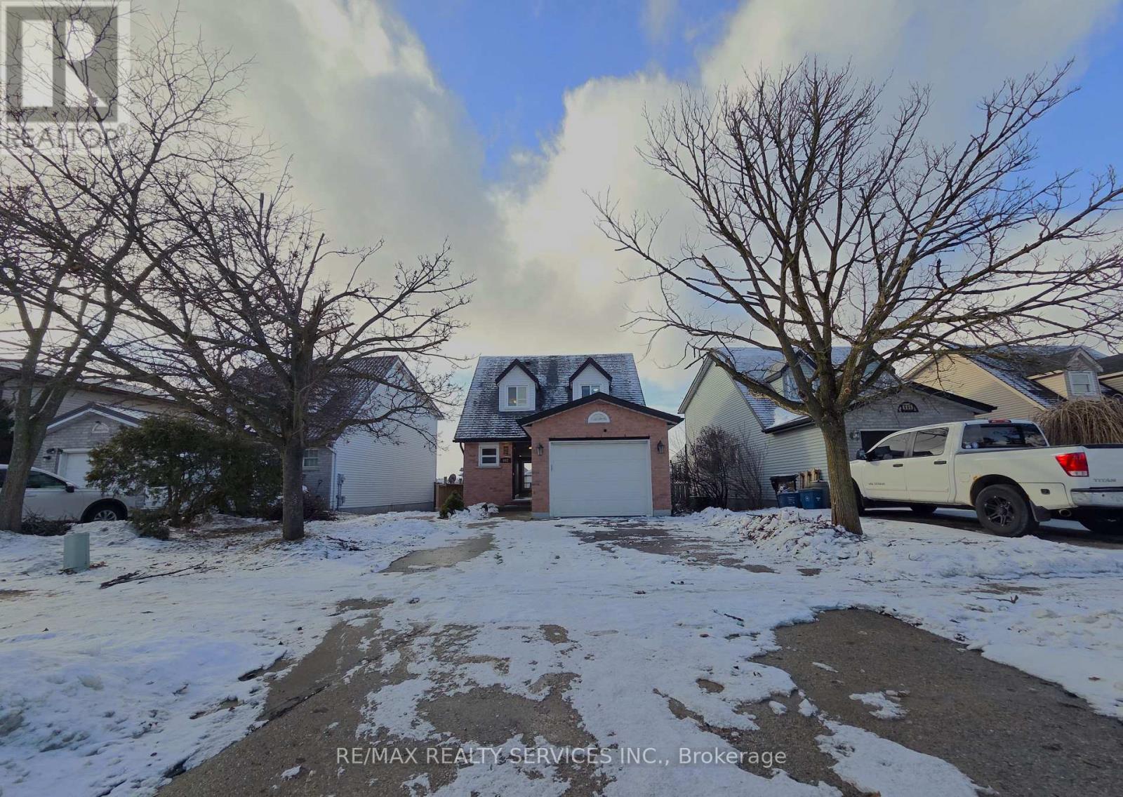 A residential area with houses and bare trees in the snow.