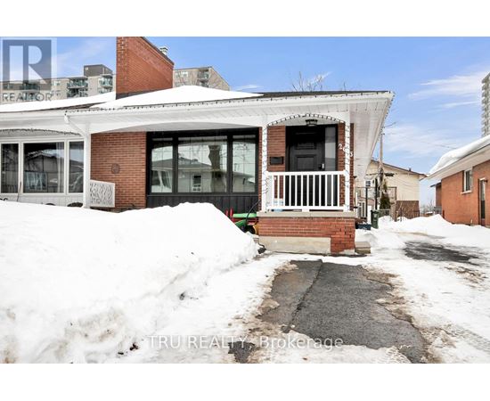 A house with a white roof and a brick chimney is surrounded by snow.