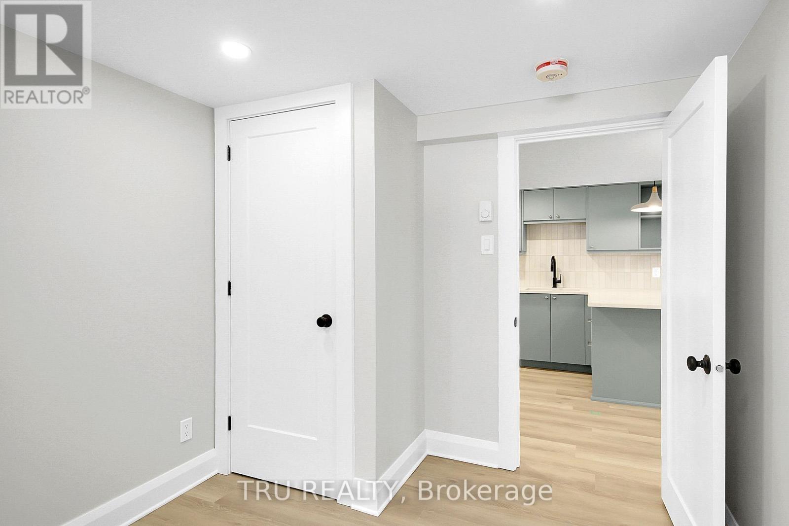A white door is open to a kitchen area.