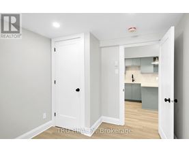 A white door is open to a kitchen area.