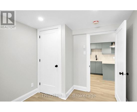 A white door is open to a kitchen area.