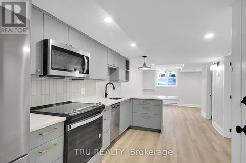 A modern kitchen with stainless steel appliances and a microwave above the stove.