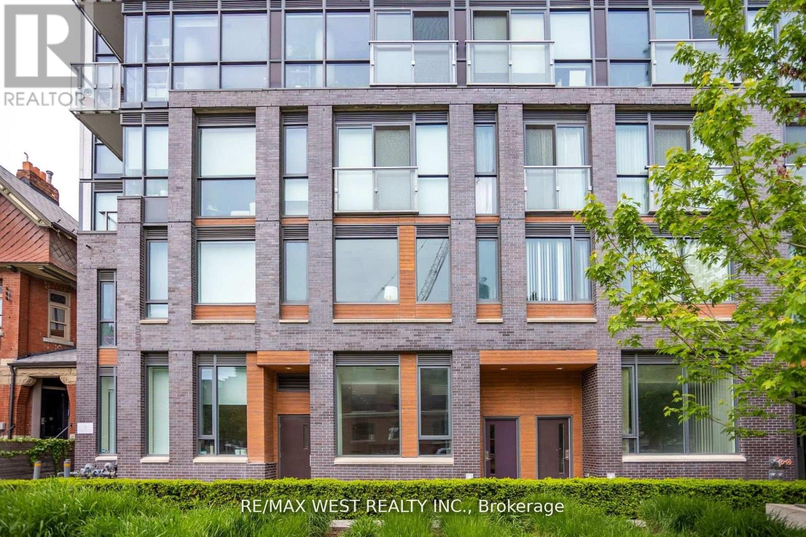 A modern building with a glass facade is shown with the RE/MAX West Realty logo in the corner.