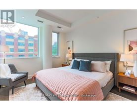 A bedroom with a large bed and a chair.