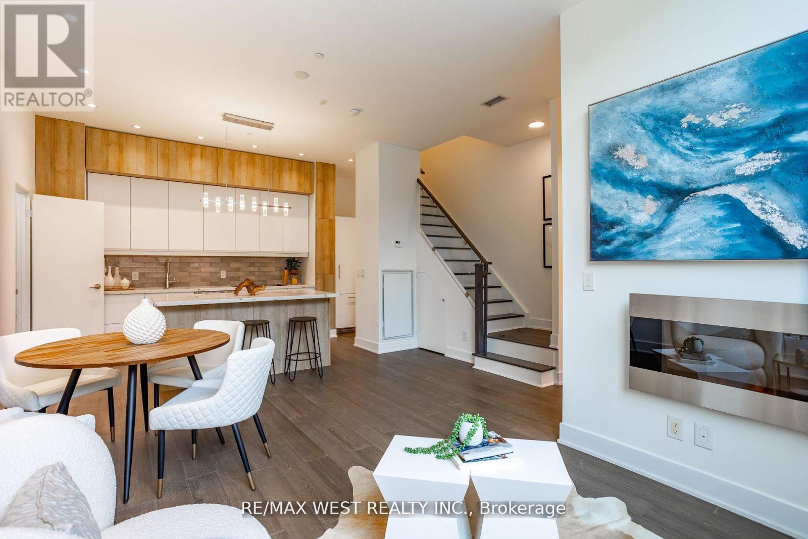 A modern living room with a wooden dining table and white chairs.