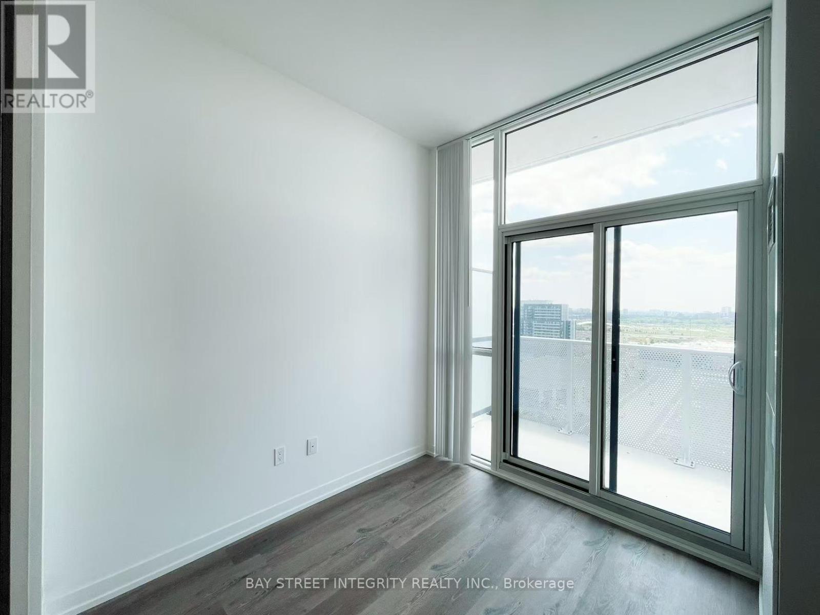 A room with a sliding glass door leading to a balcony.