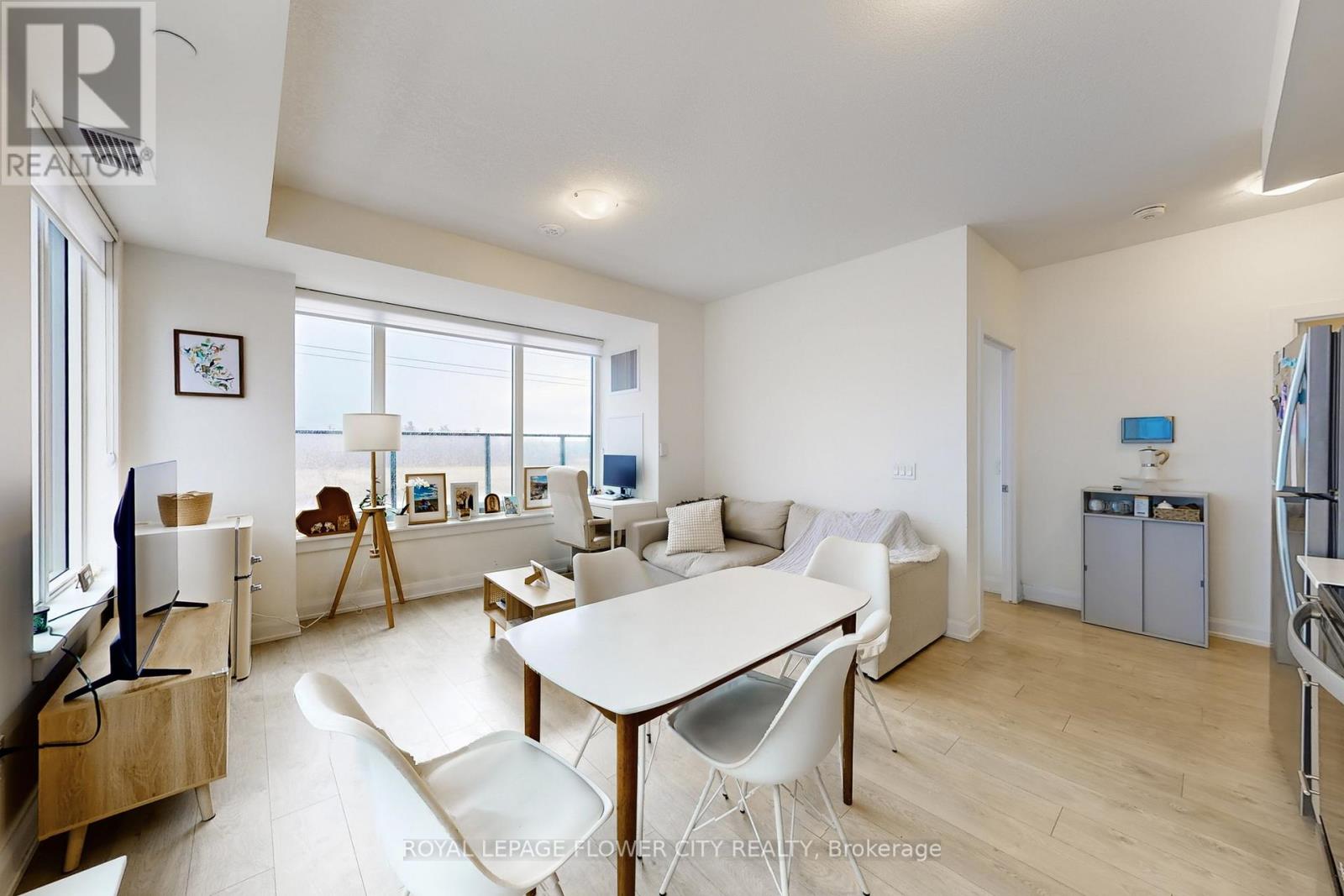 A well-lit, spacious living room with a dining table and chairs.