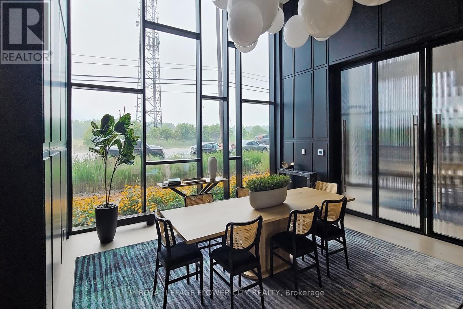A dining room with a table and chairs and a view of the outside.