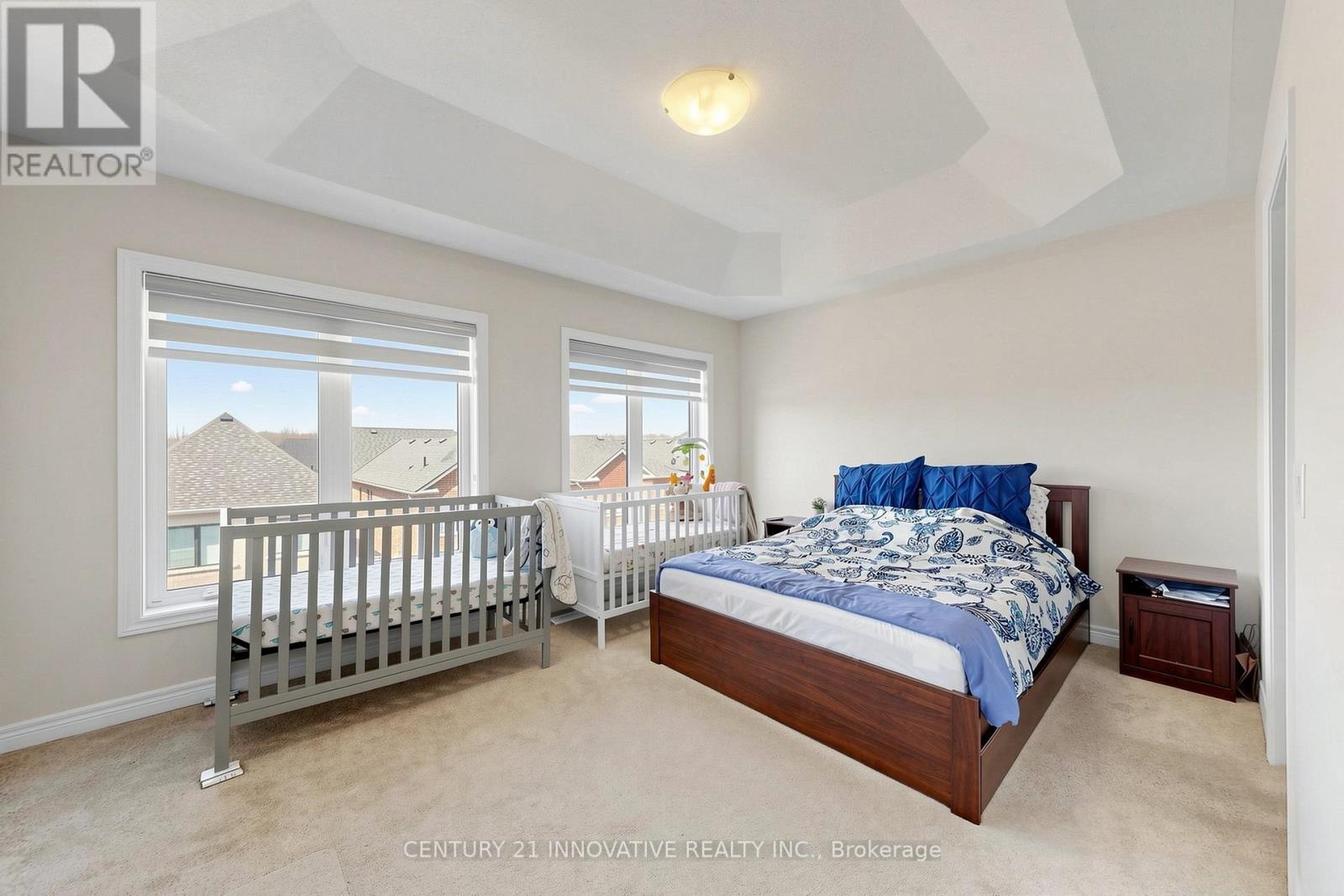 A bedroom with a large bed and a crib is shown.