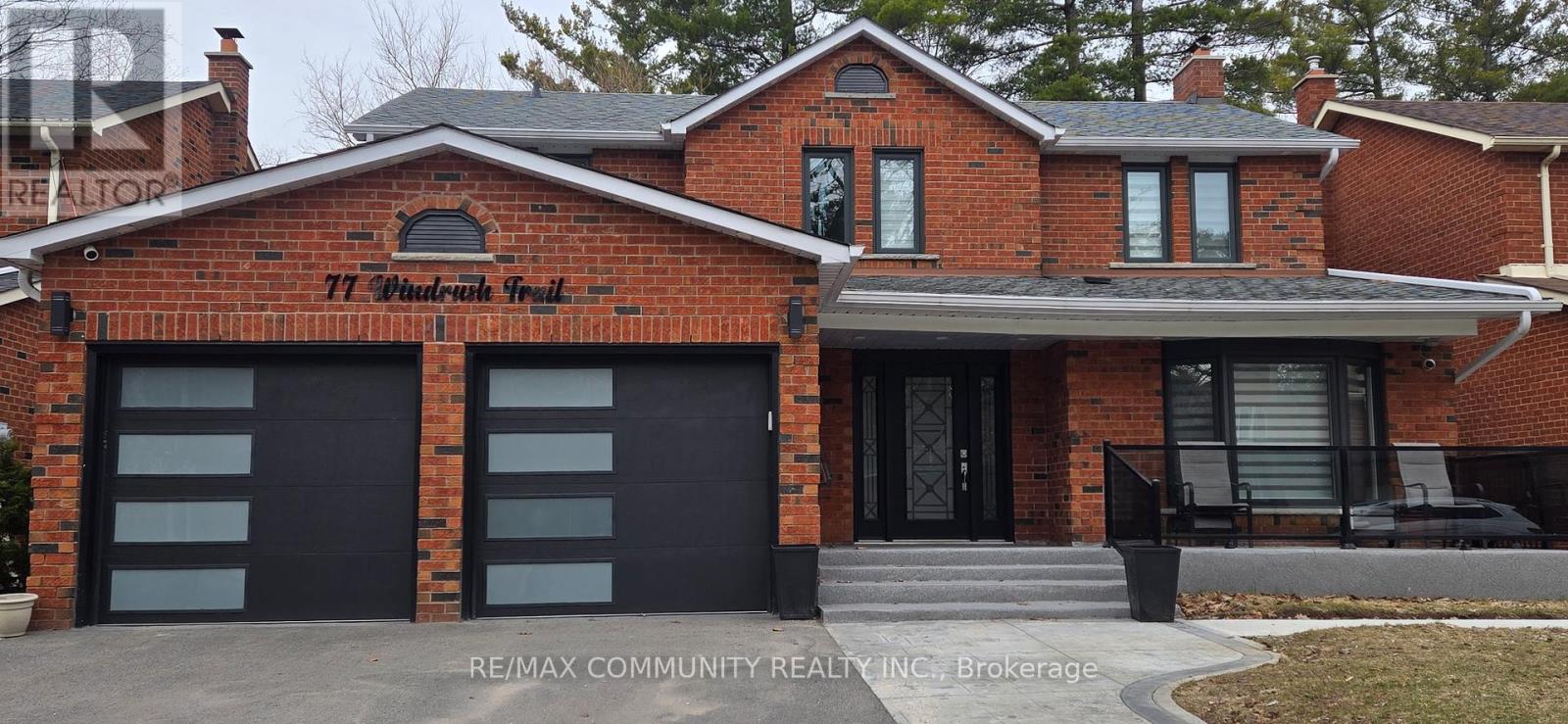 A red brick house with a black garage door.