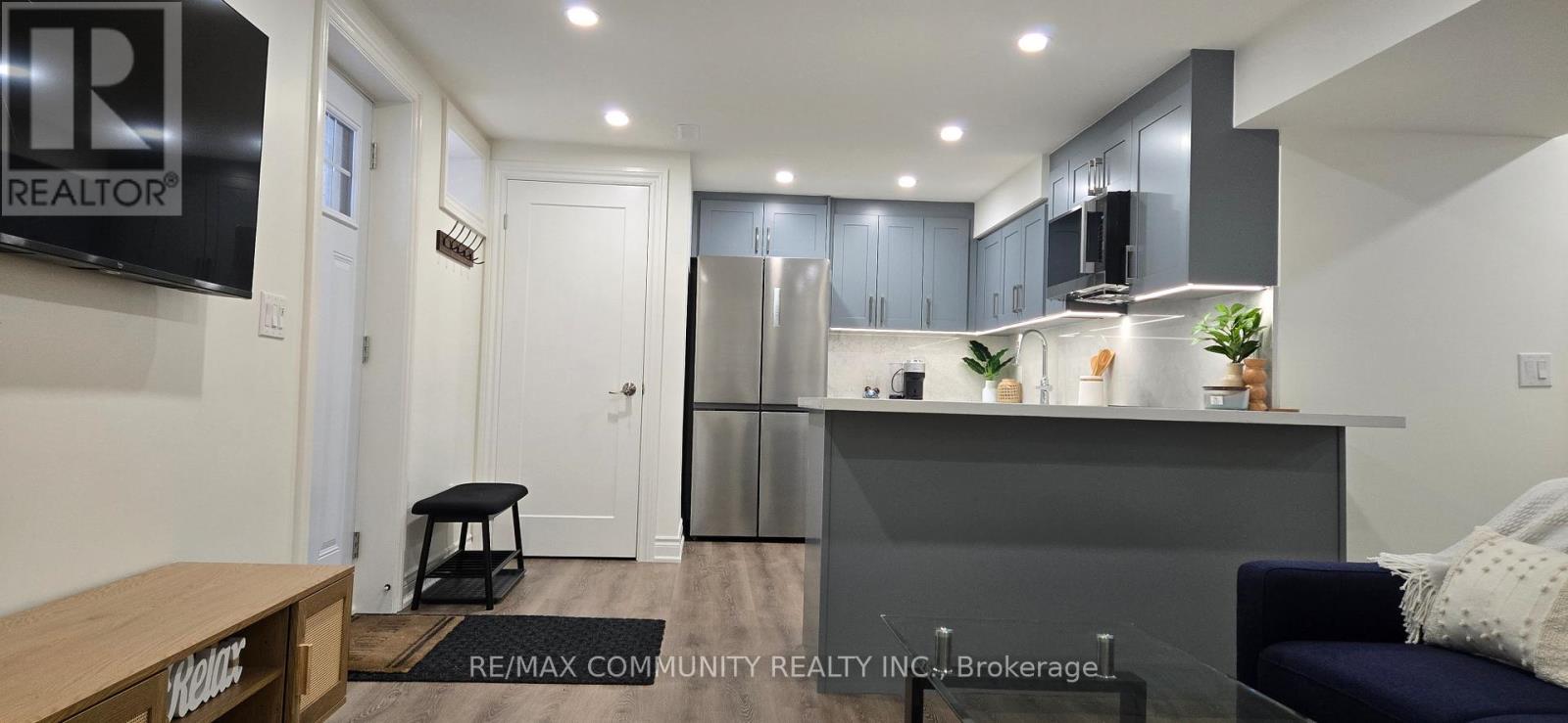 A modern kitchen with a refrigerator, cabinets, and a countertop.