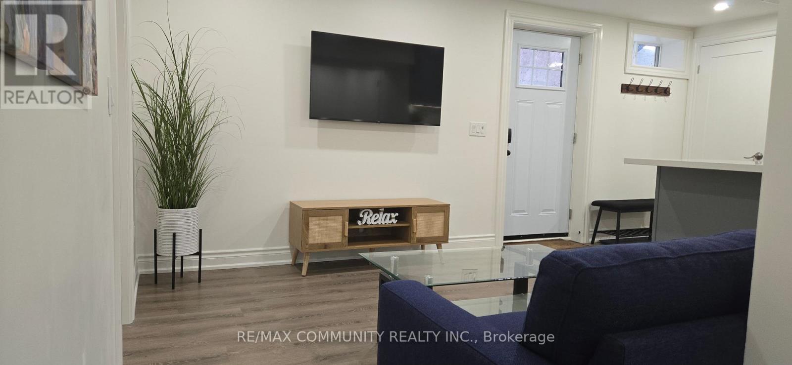 A living room with a blue couch and a wooden table with a sign that says "Re/Max".