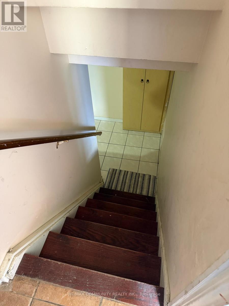 A staircase with wooden steps and a white wall.