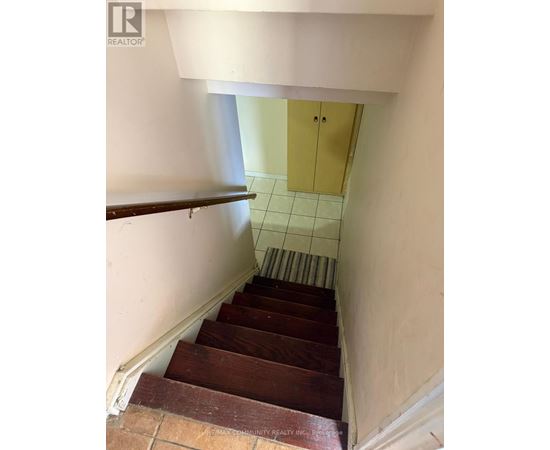 A staircase with wooden steps and a white wall.