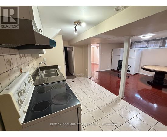 A kitchen with a stove top oven and a refrigerator.