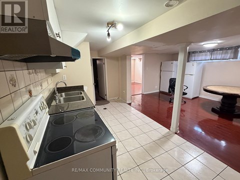 A kitchen with a stove top oven and a refrigerator.