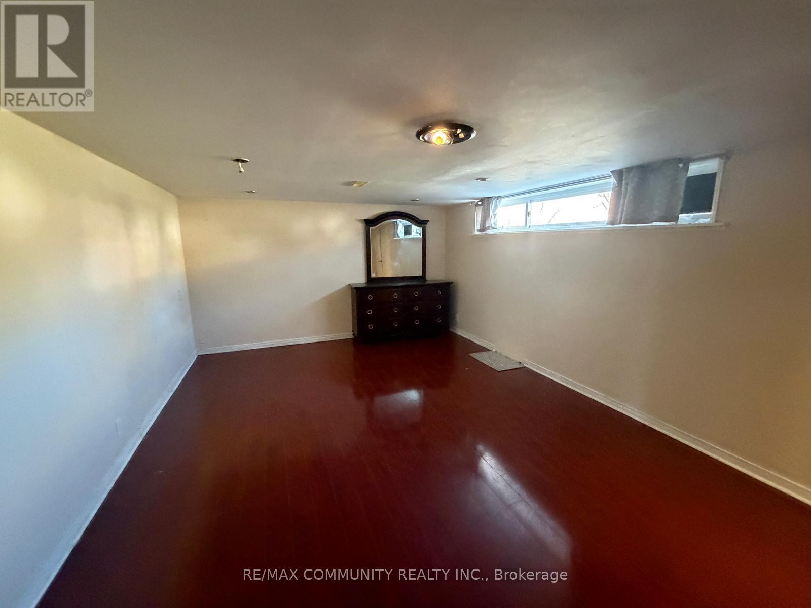 A room with a wooden floor and a television set.
