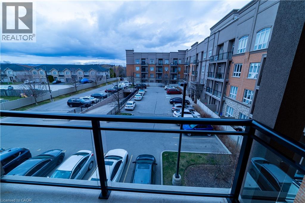 A view from a balcony overlooking a parking lot and apartment buildings.