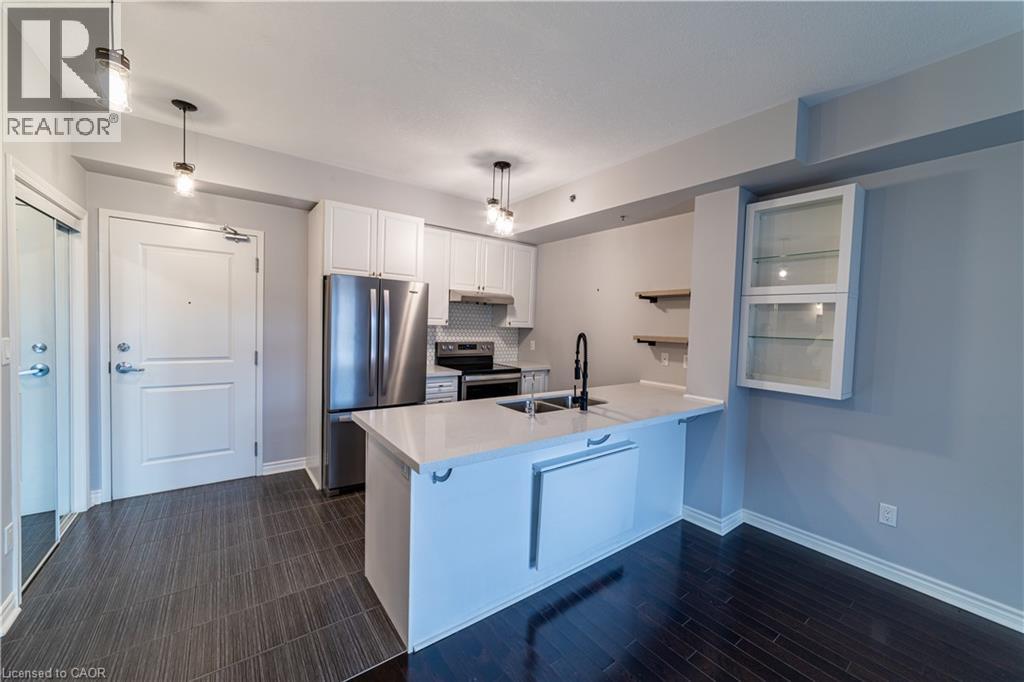 A kitchen with white cabinets and a stainless steel refrigerator.