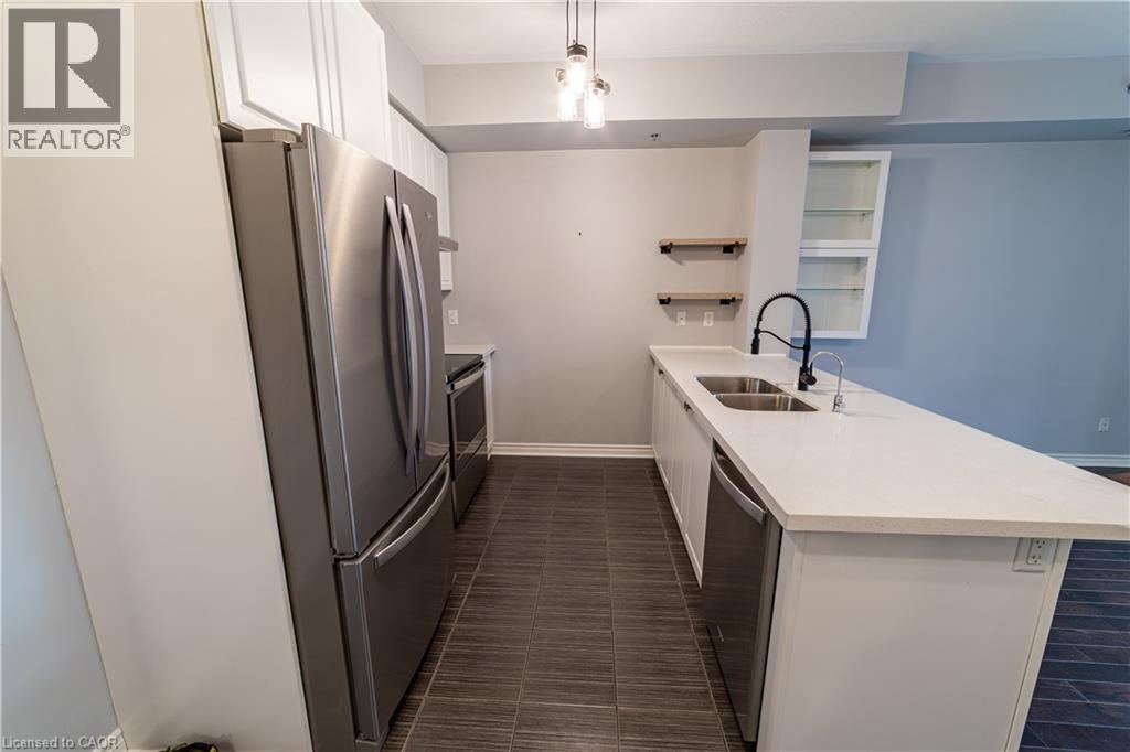 A modern kitchen with a white countertop and stainless steel appliances.