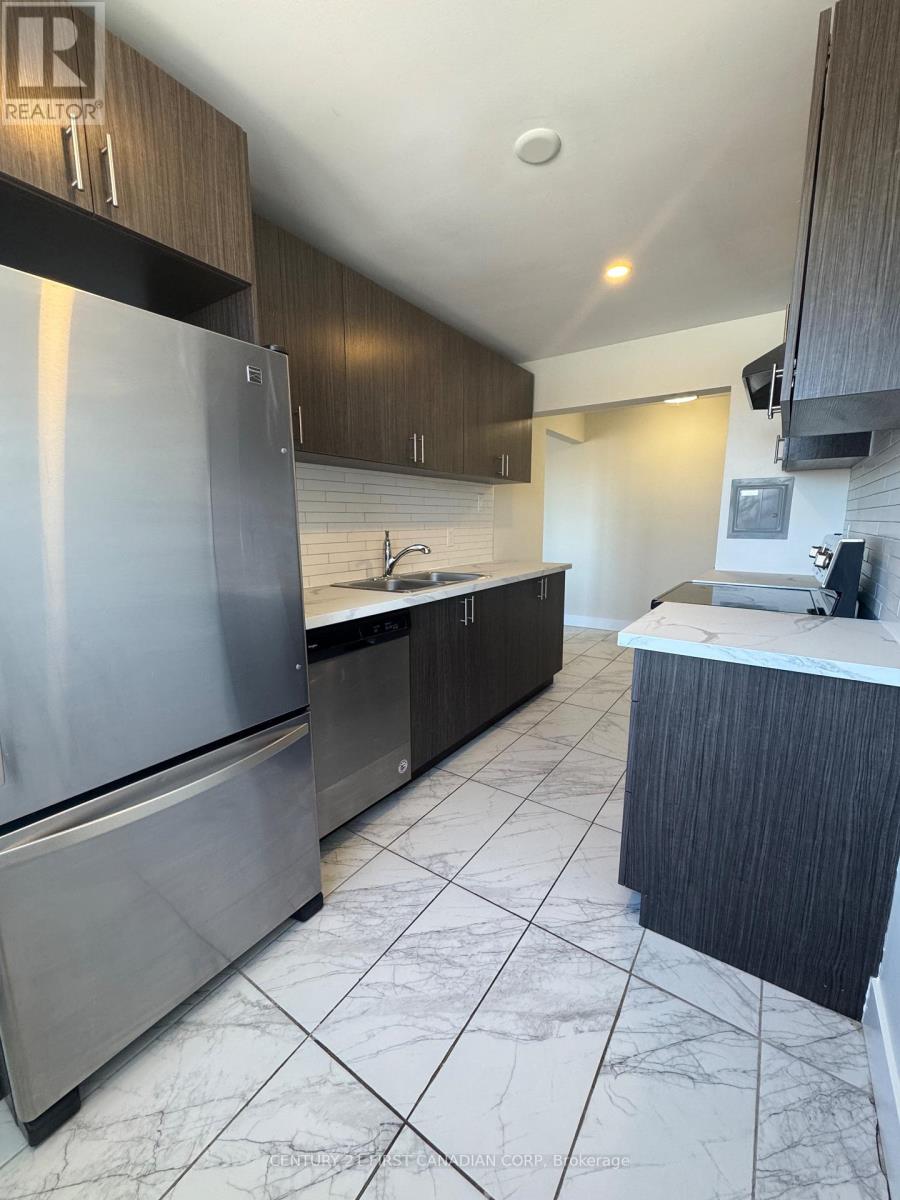 A modern kitchen with a stainless steel refrigerator and dark wood cabinets.
