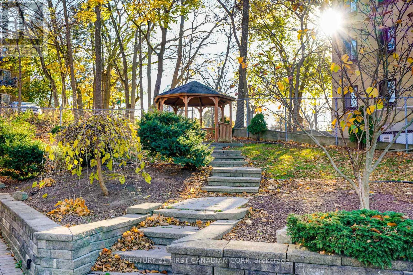 A gazebo is surrounded by trees and plants in a park.